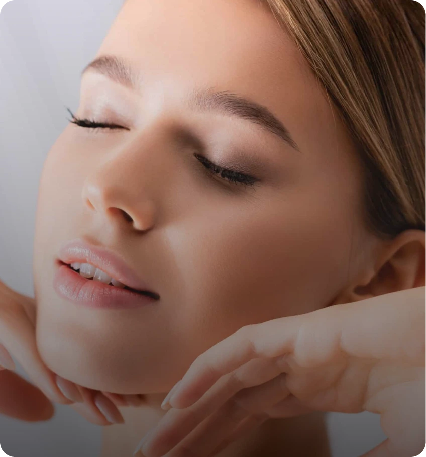 Woman with clear skin touching her face with eyes closed
